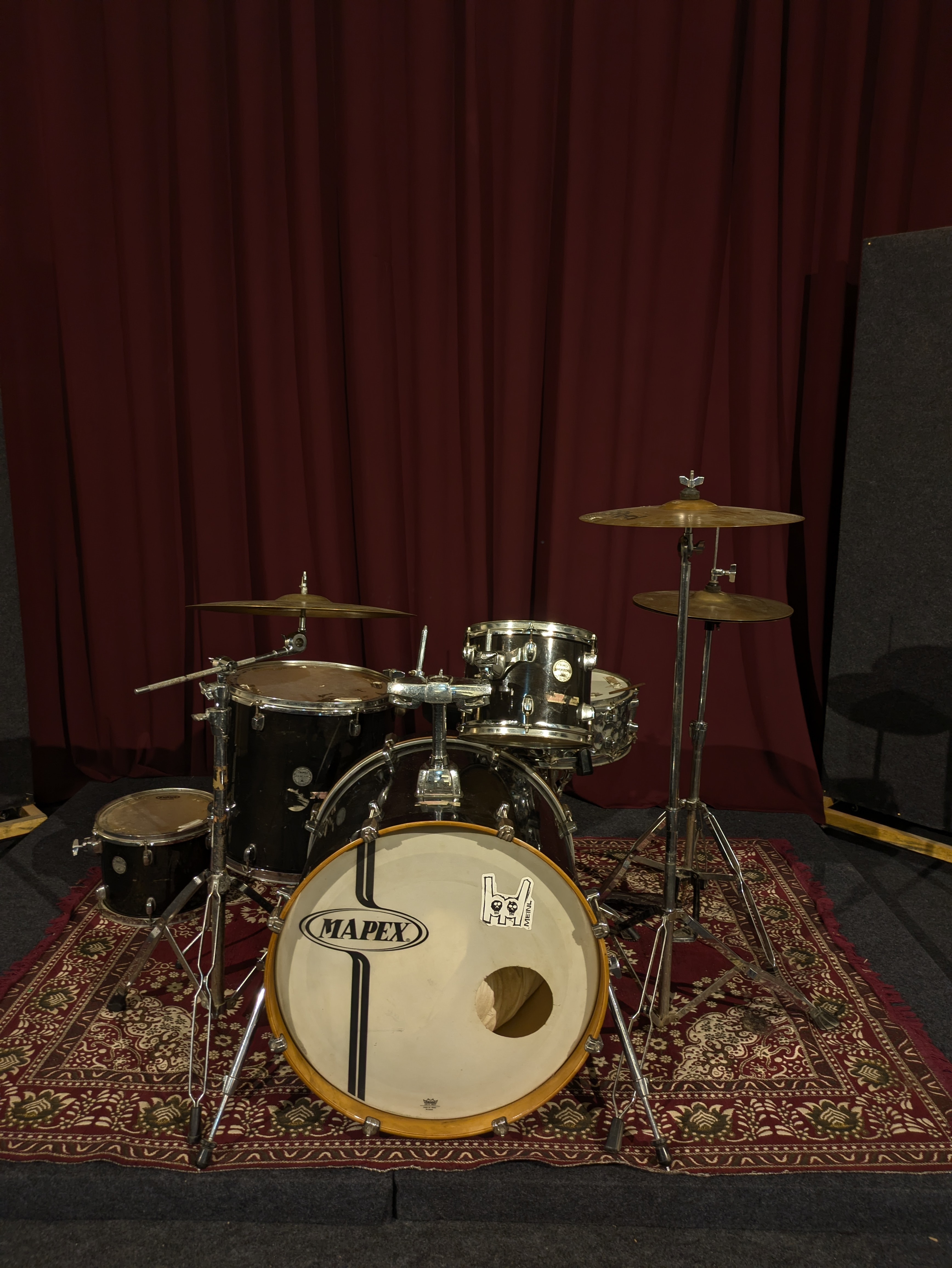 Mapex acoustic drum kit set up on the rug with cymbals and hardware